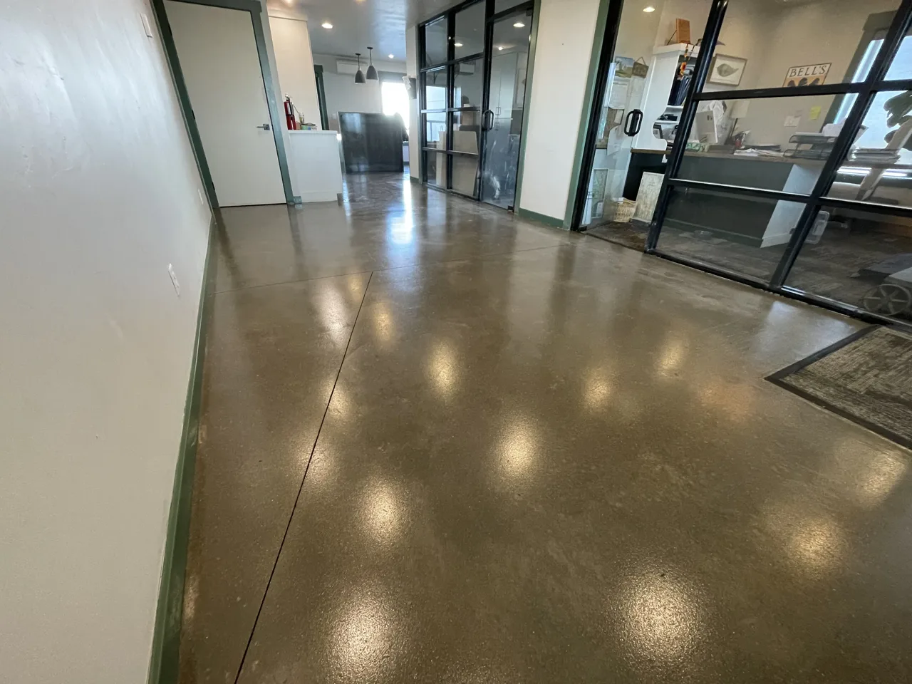Brown-toned concrete floor across a glass-walled commercial interior