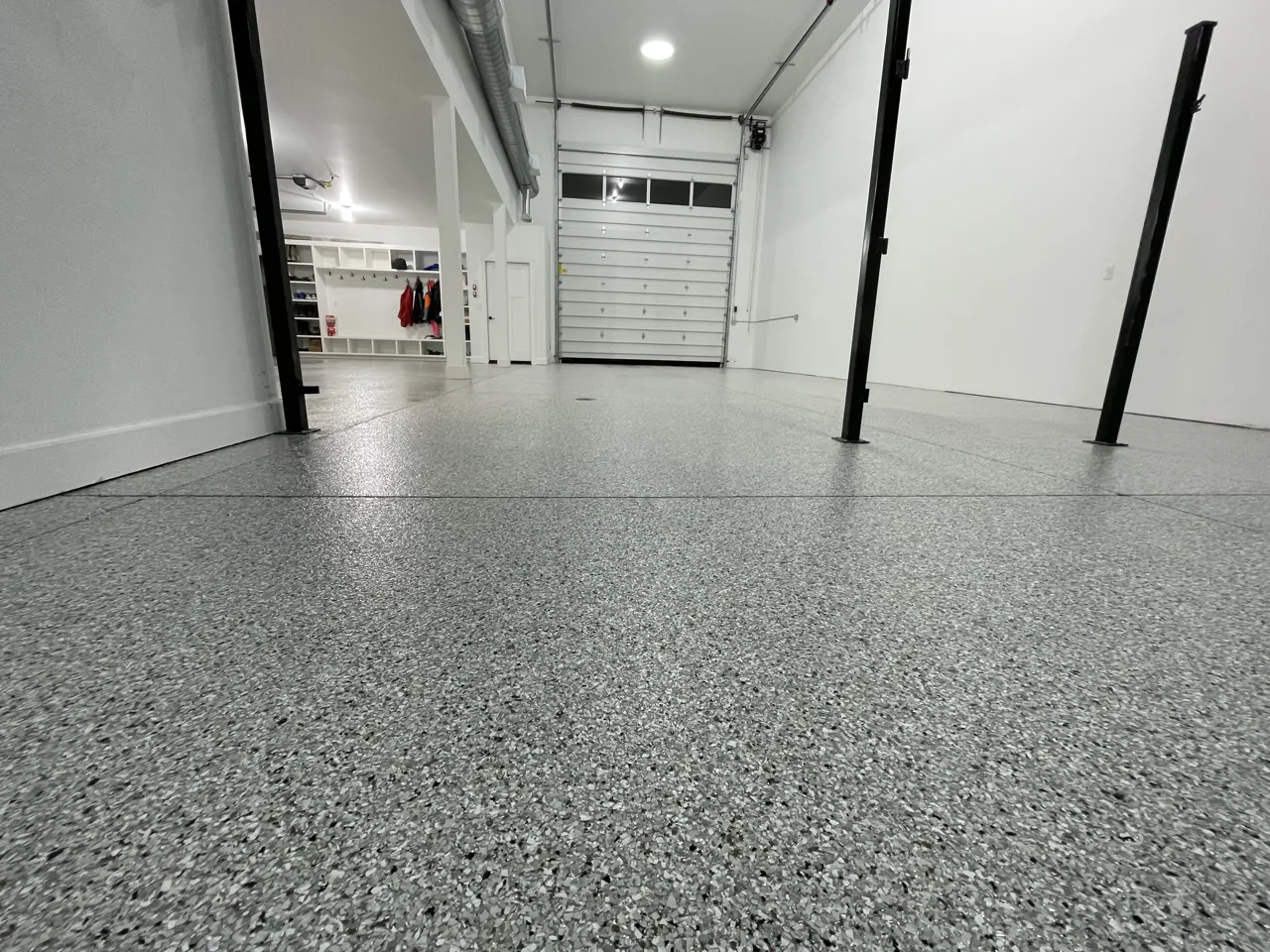 Gray flake garage floor between black support posts