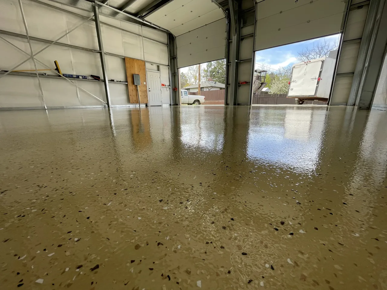 Close view of tan flake shop flooring with the overhead door open